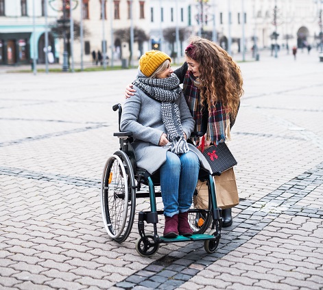 Symboldbild: Junge Frau mit älterer Dame im Rollstuhl